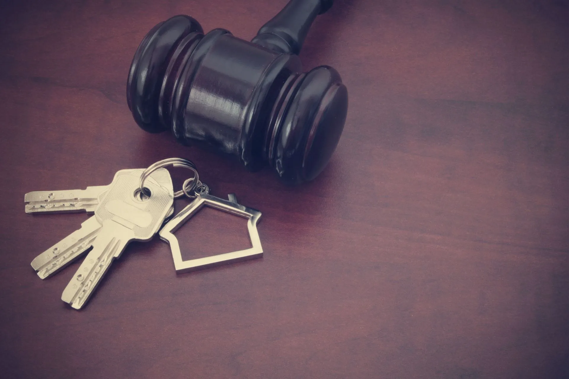 Gavel and house keys on table