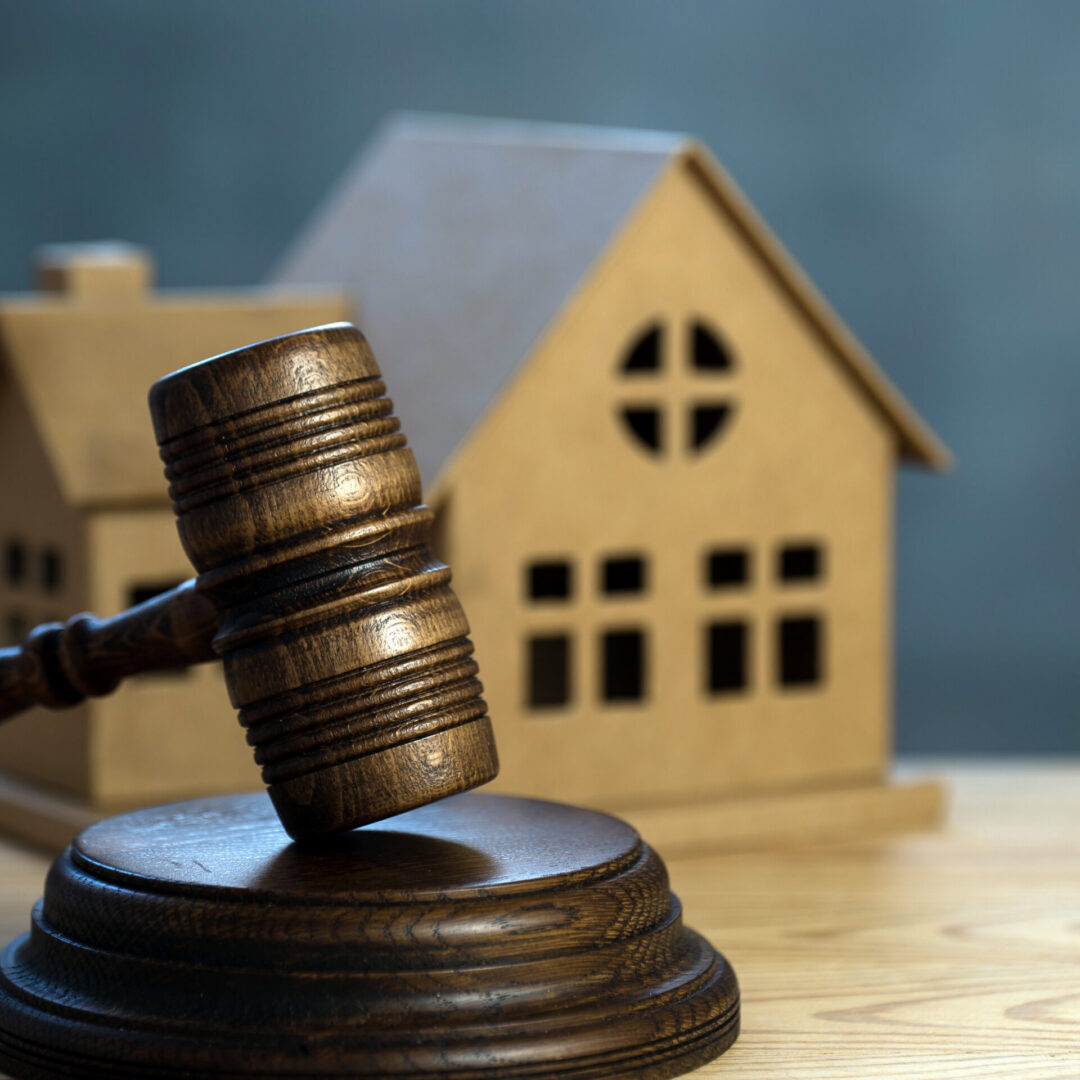 House auctions. A wooden hammer and a paper house